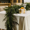 Juleborddekoration med grøn guirlande og gave